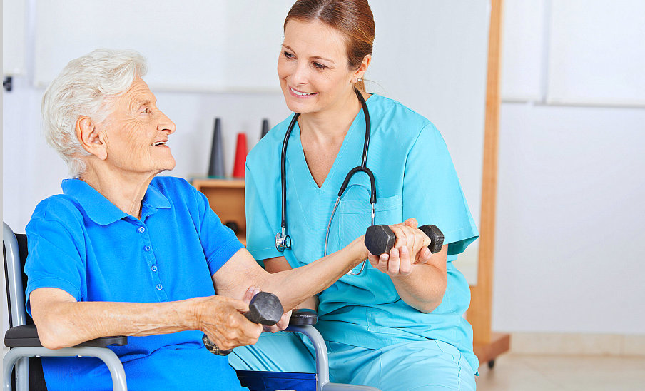 nurse assisting patient in her exercise